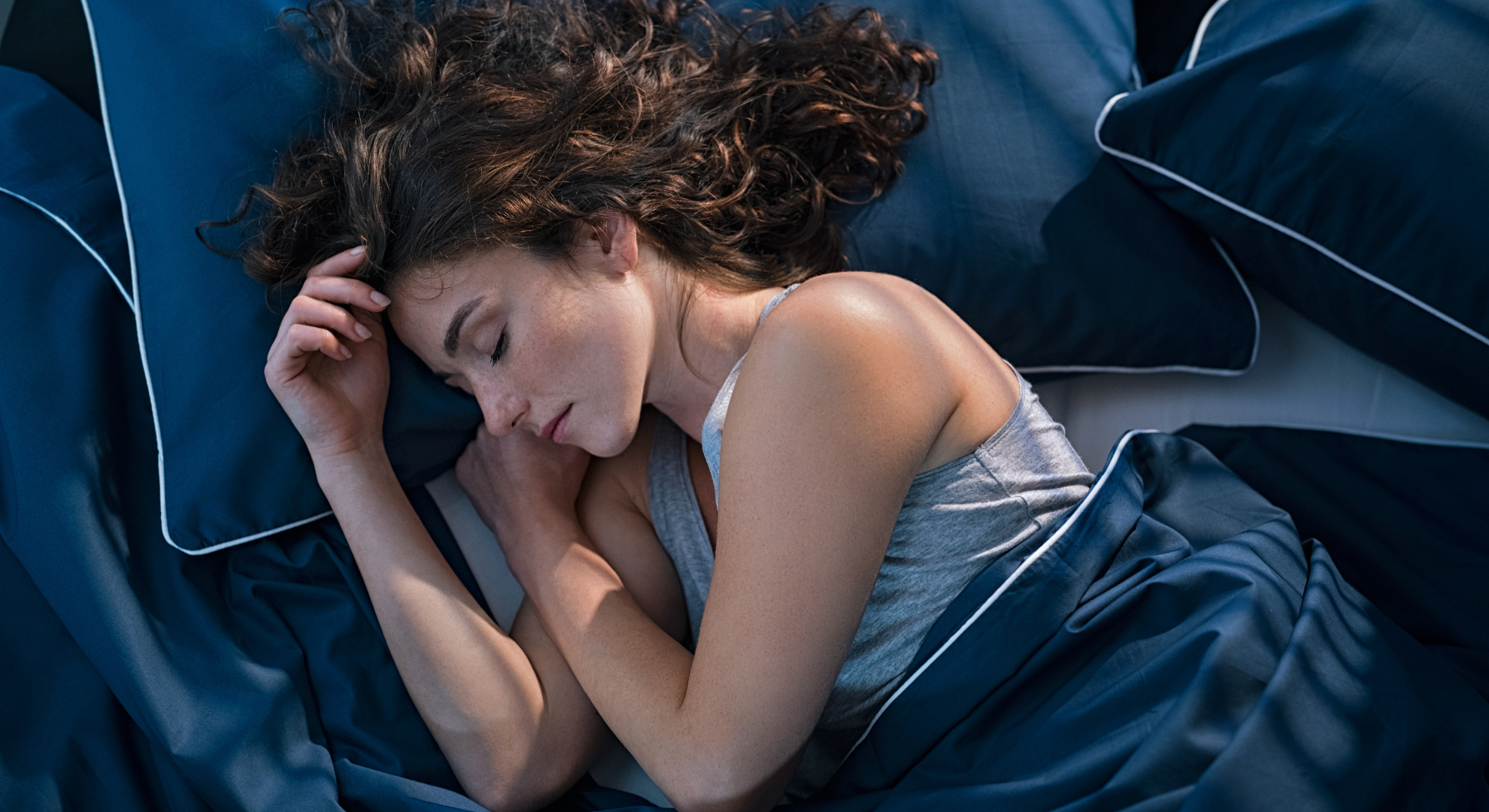 Person sleeping at night, illustrating the body’s primary window for cellular repair, autophagy, and recovery