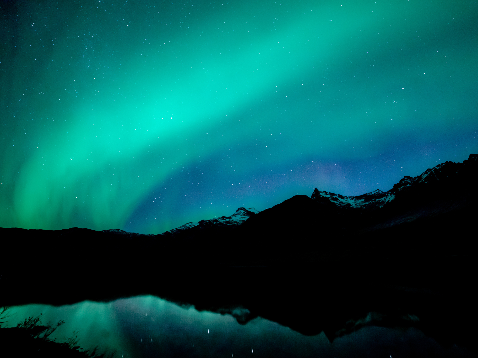 Northern lights over mountains representing cellular repair and autophagy processes during nighttime.