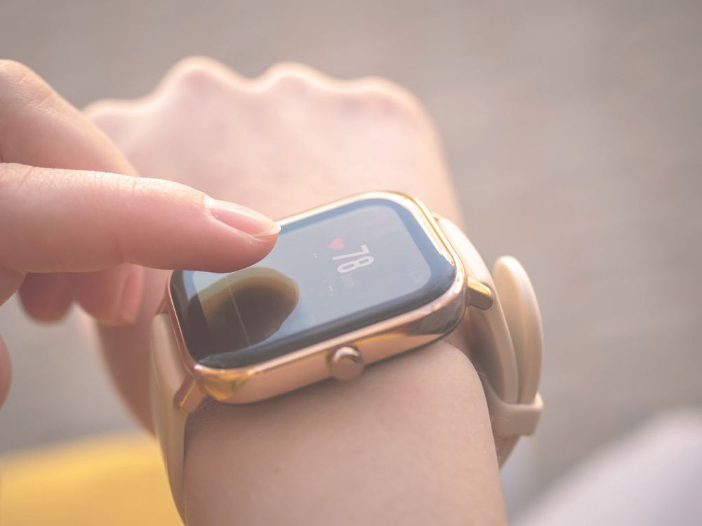 Person checking health metrics on a smartwatch to track recovery and daily readiness