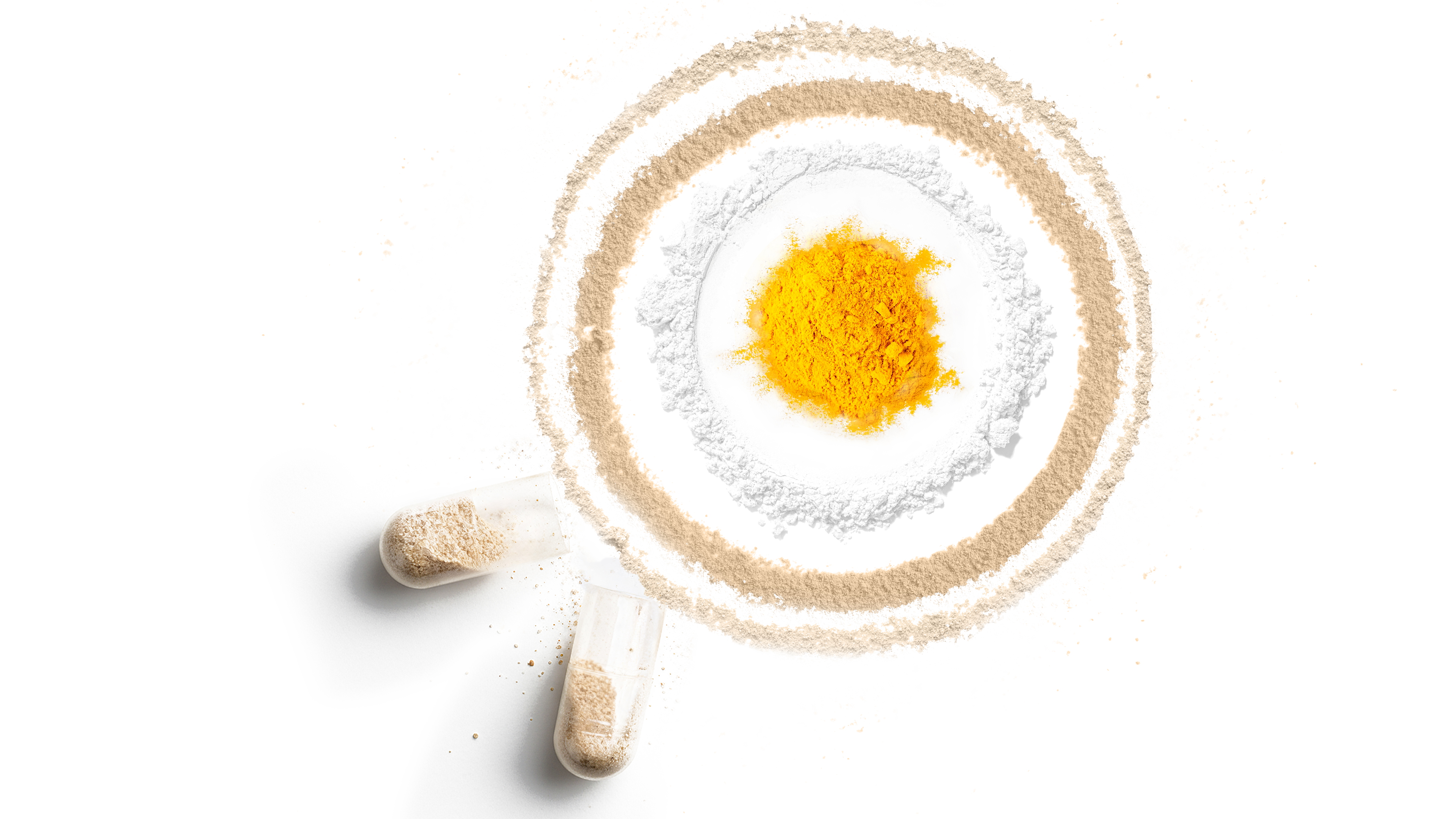 Powder blend arranged in circular rings with two capsules on a neutral background.